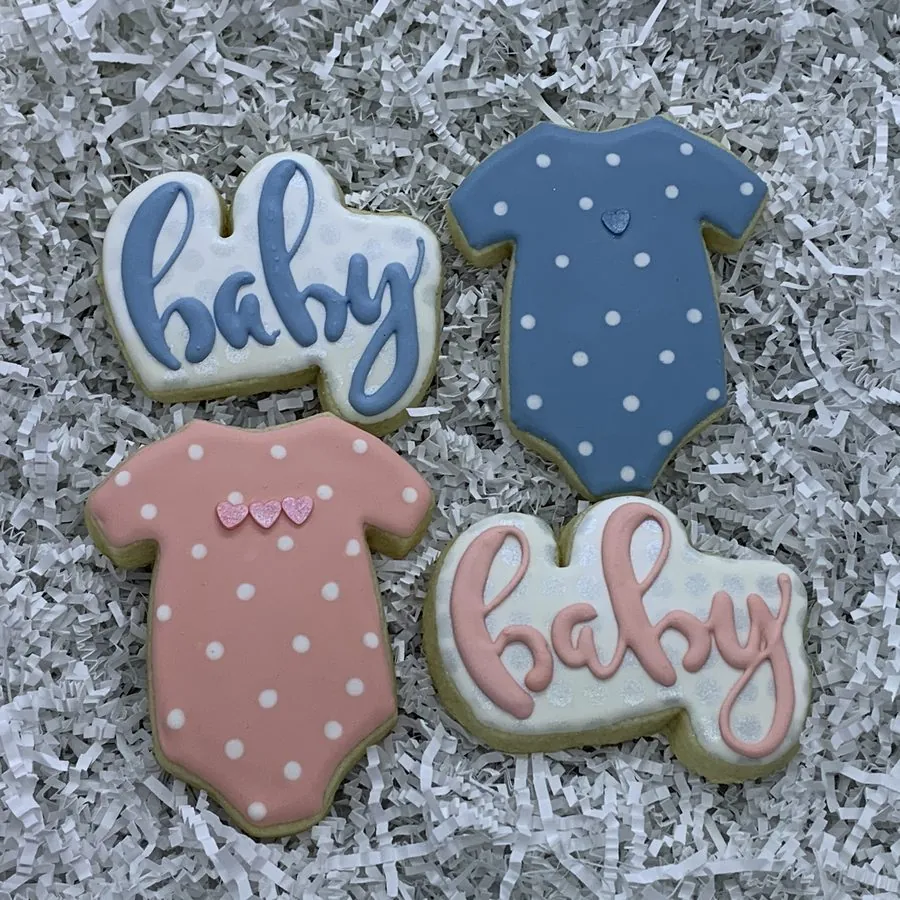 Pink and blue polka-dot onesie cookies with piped baby plaques