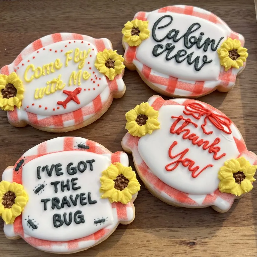 Piped cookies reading cabin crew, come fly with me, and thank you, with sunflowers