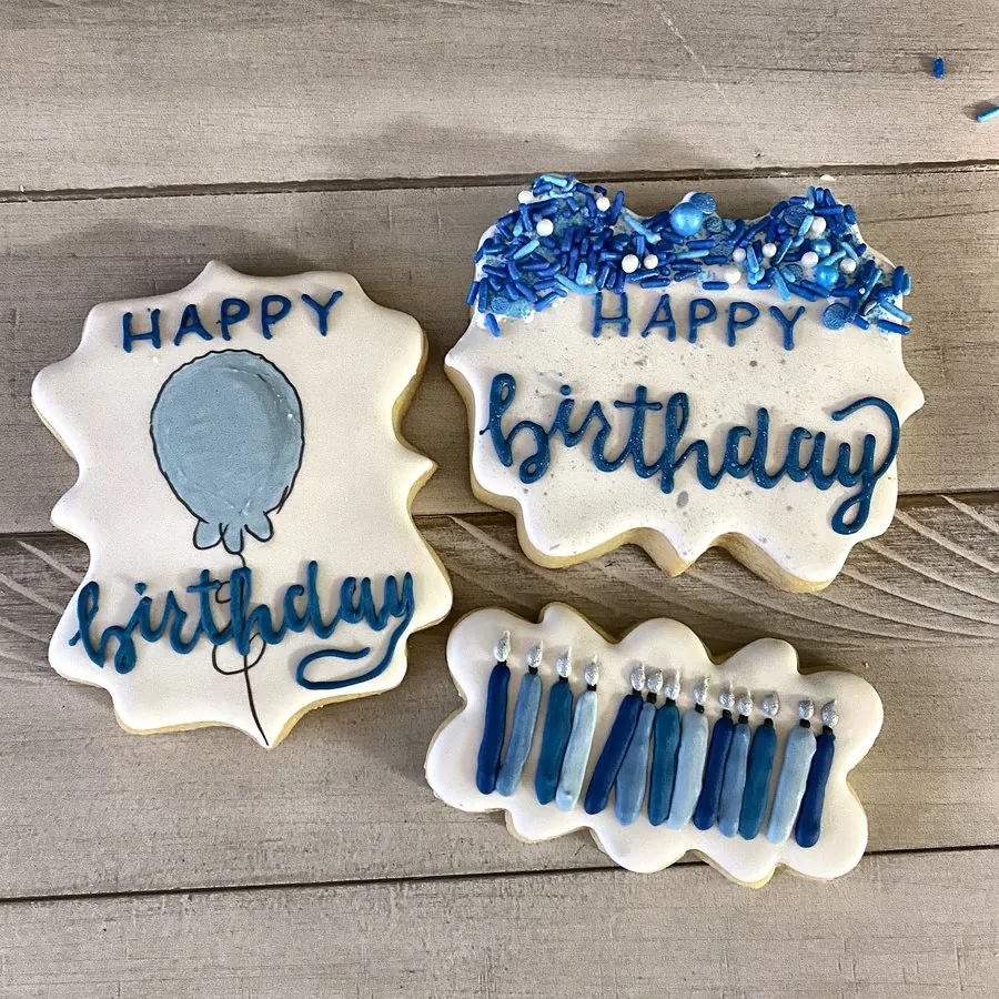 Blue and white happy birthday cookies with a balloon and candles