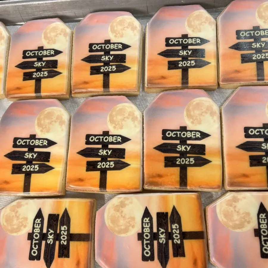 Cookies printed with a sunset and October Sky 2025 signposts