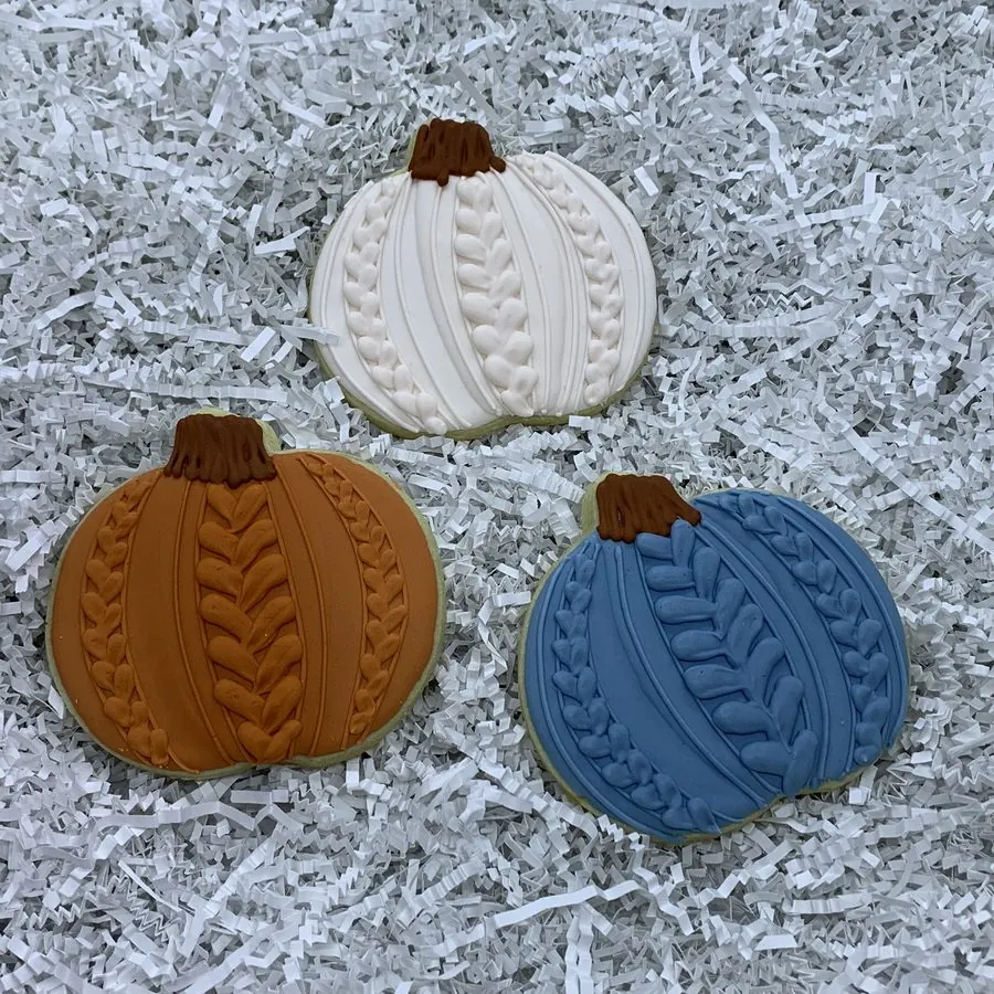 Pumpkin cookies piped with a knit sweater texture